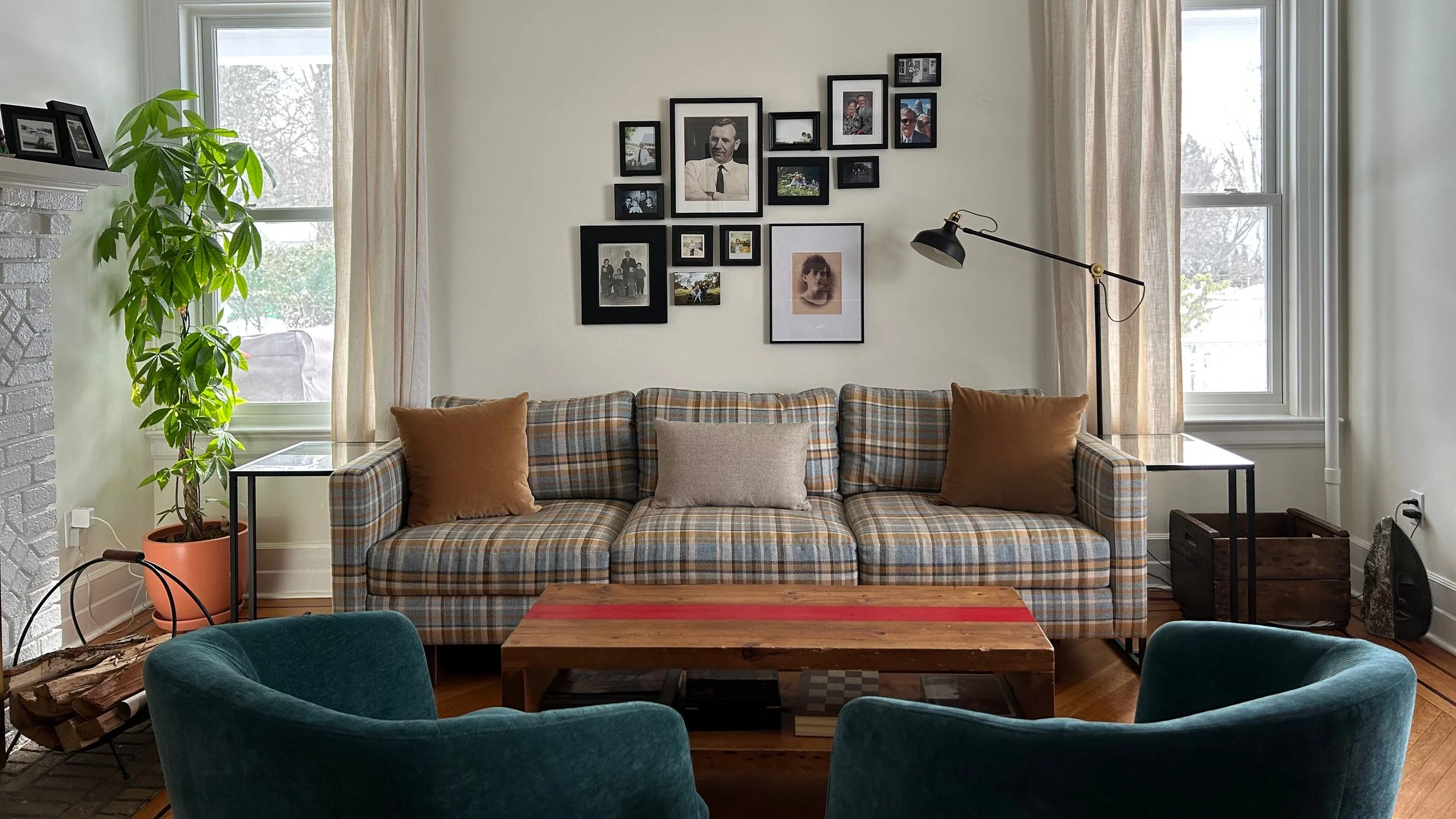 Plaid couch with a gallery wall behind it in a living room.