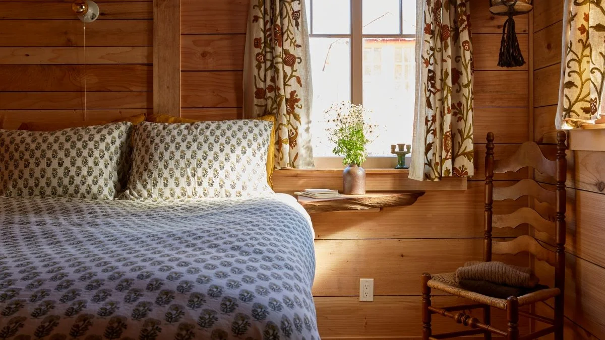 Image may contain Indoors Interior Design Chair Furniture Plant Wood Panels Wood Bed Hardwood and Stained Wood