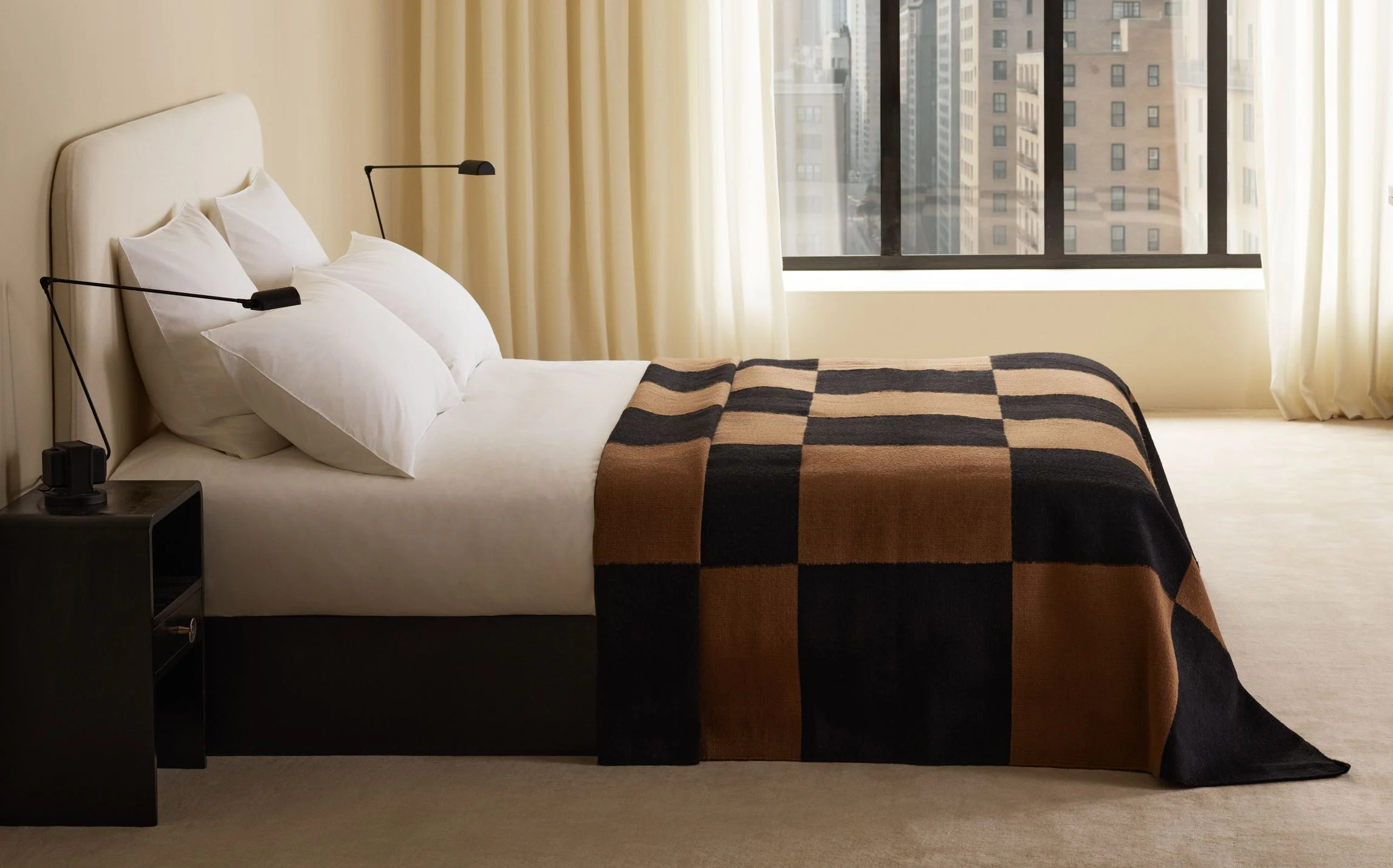Bedroom with checkered blanket on the end of the bed.