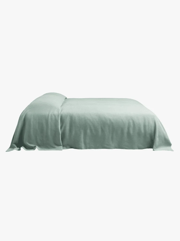 Mint green sheets draped over a mattress