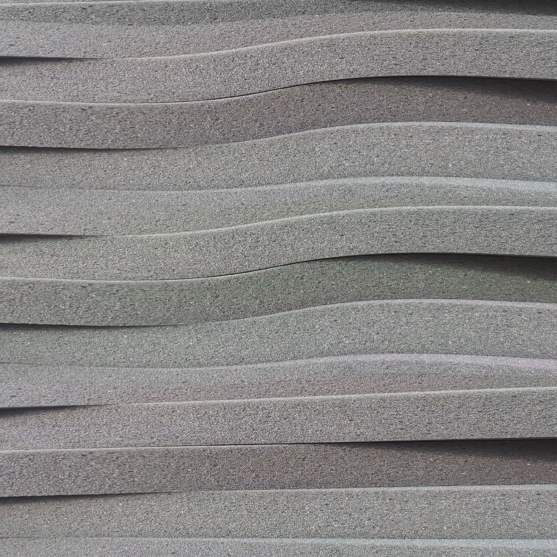 Thin grey foam sheet material arranged in a stack.