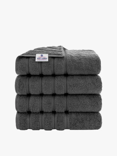 Stack of four gray folded bath towels.