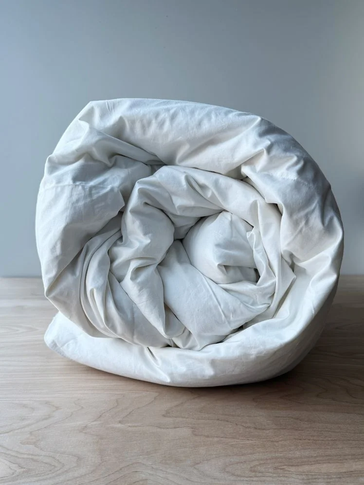 Rolled up white comforter.