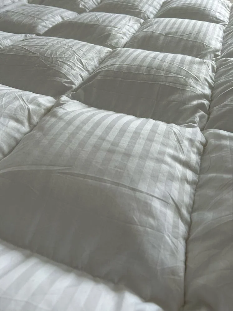 Closeup of white square stitch duvet.