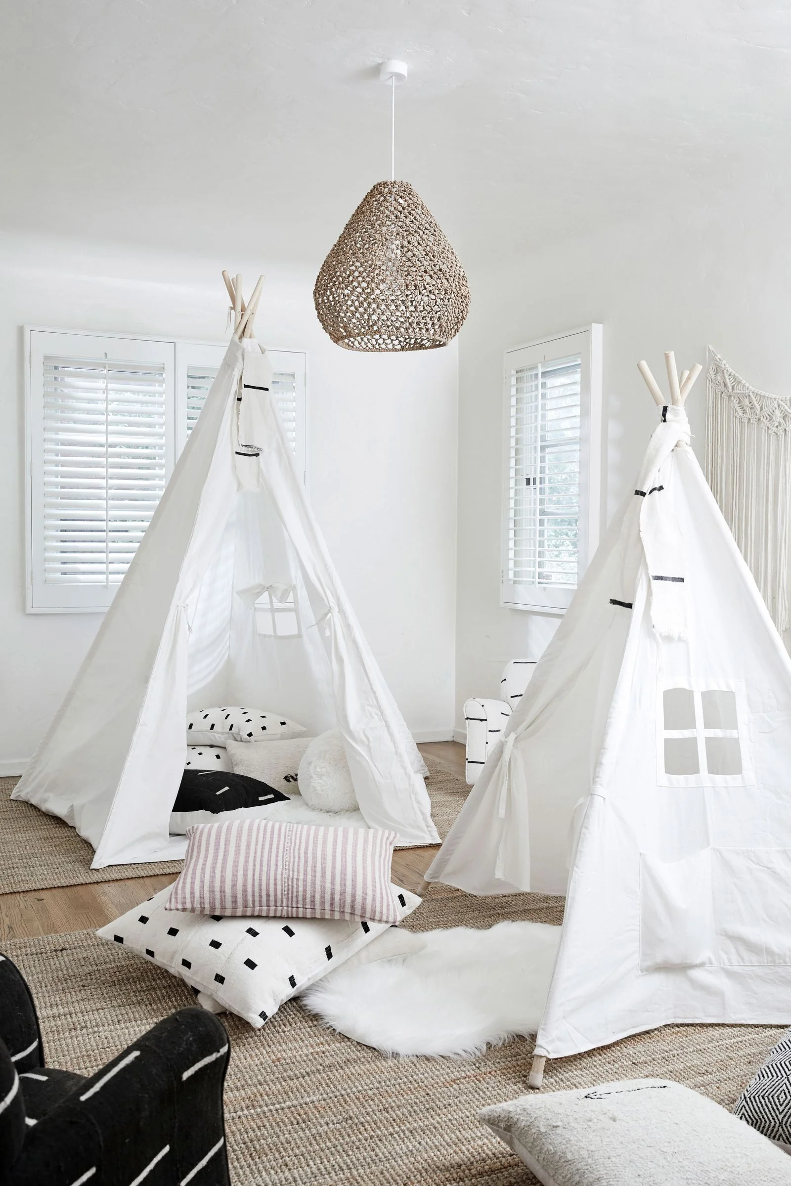 a white playroom with teepees