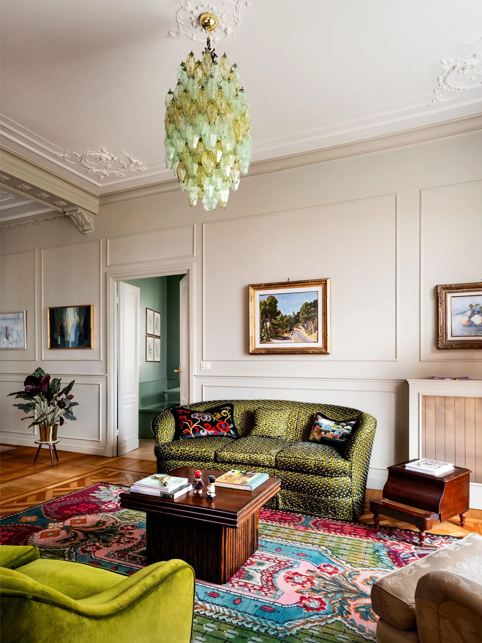 divano verde tappeto colorato boiserie