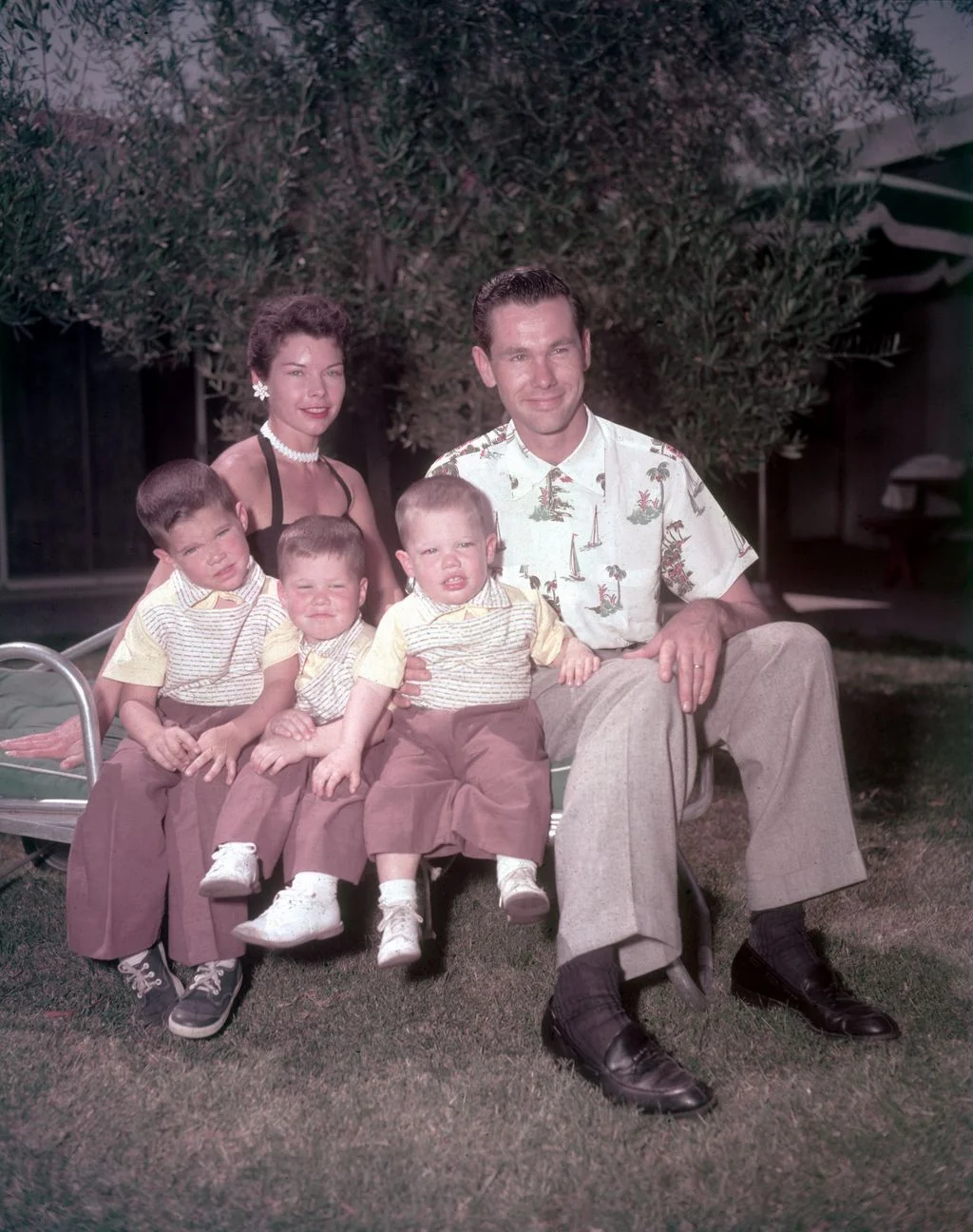 Jody Wolcott Johnny Carson seated on lawn chair with three young sons seated in matching outfits with them tree in...