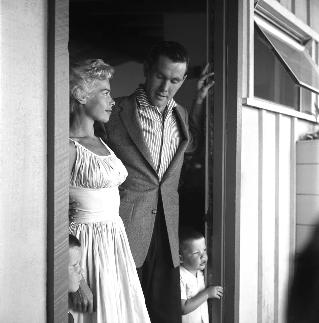 blackandwhite photo of Jody and Johnny Carson standing in doorway