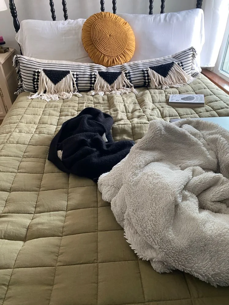 Made up bed featuring a sage linen quilt