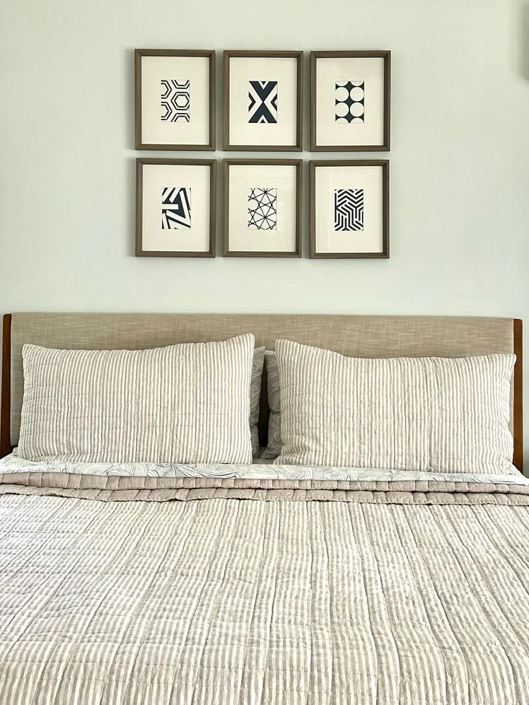 Bed made with striped quilt and matching pillows.