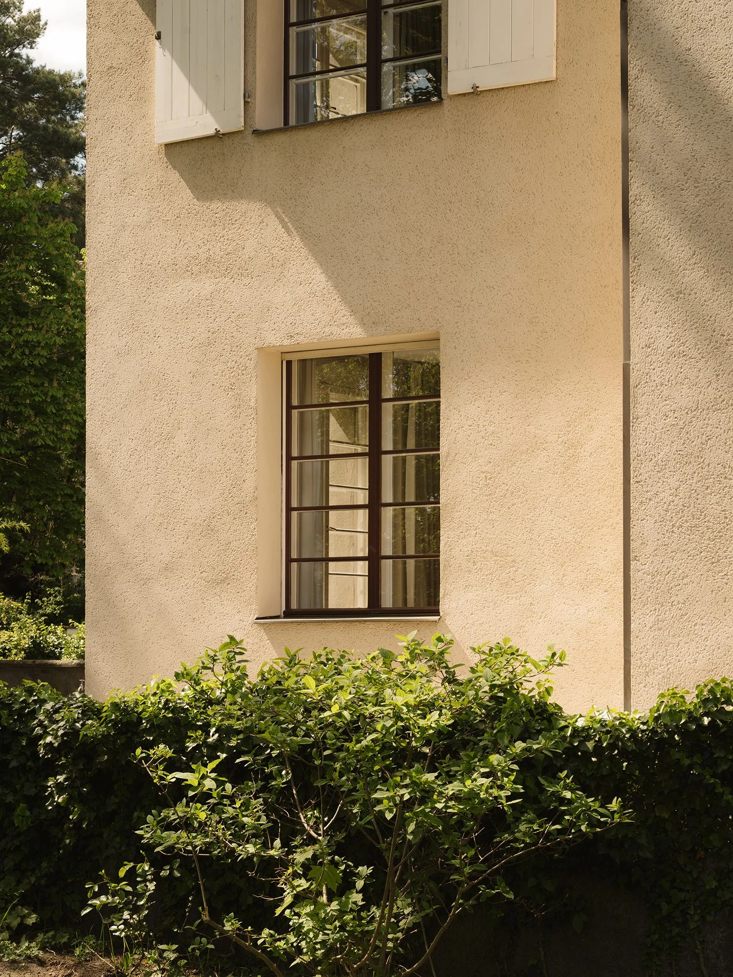 Haus Otte nach Sanierung originaler Außenputz in hellem Sandton und restaurierte historische Doppelkastenfenster.