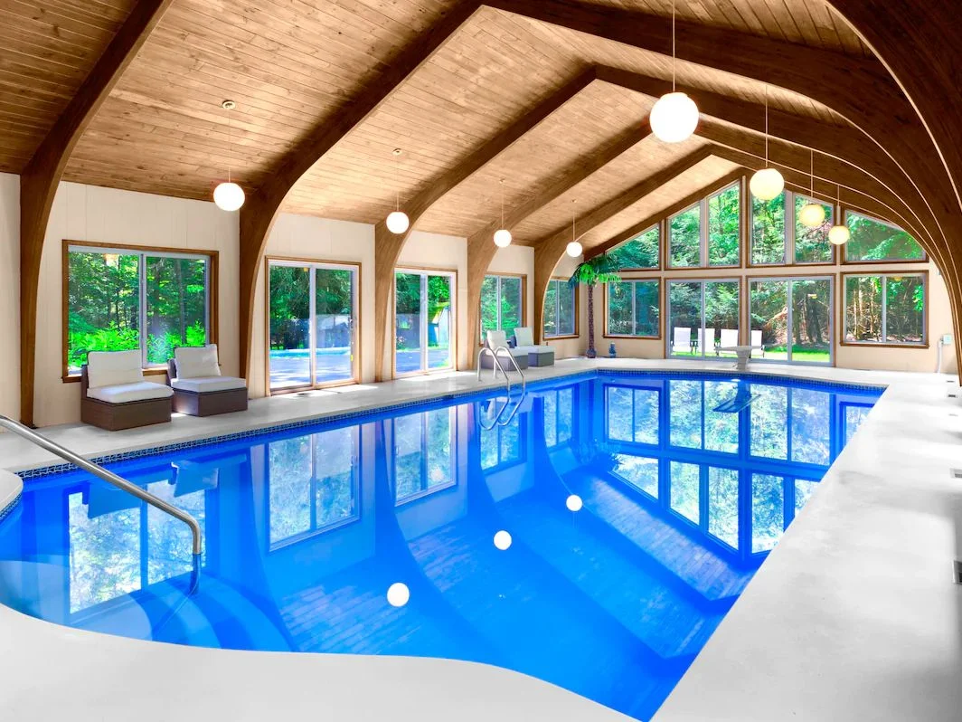 Indoor pool in a room with vaulted woodpaneled ceilings.