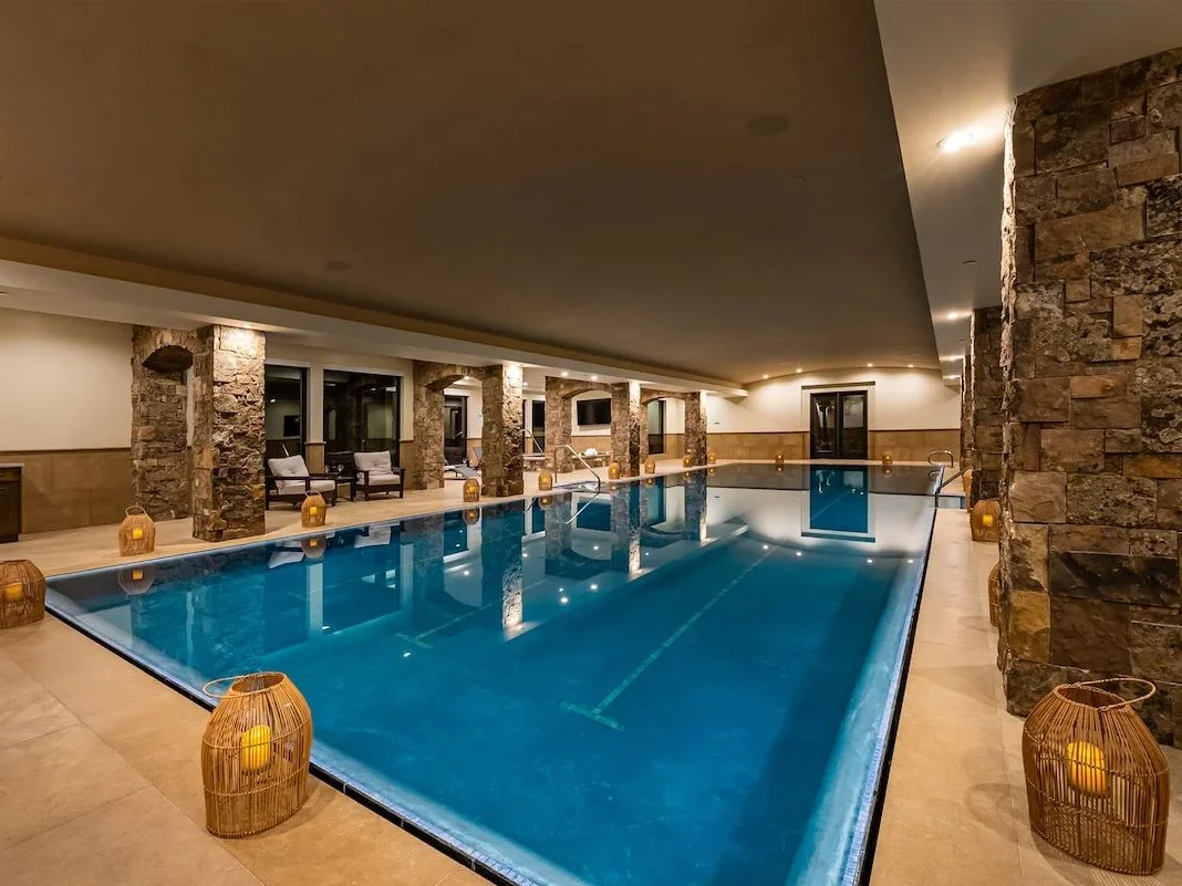A large indoor pool surrounded by stone pillars and lanterns