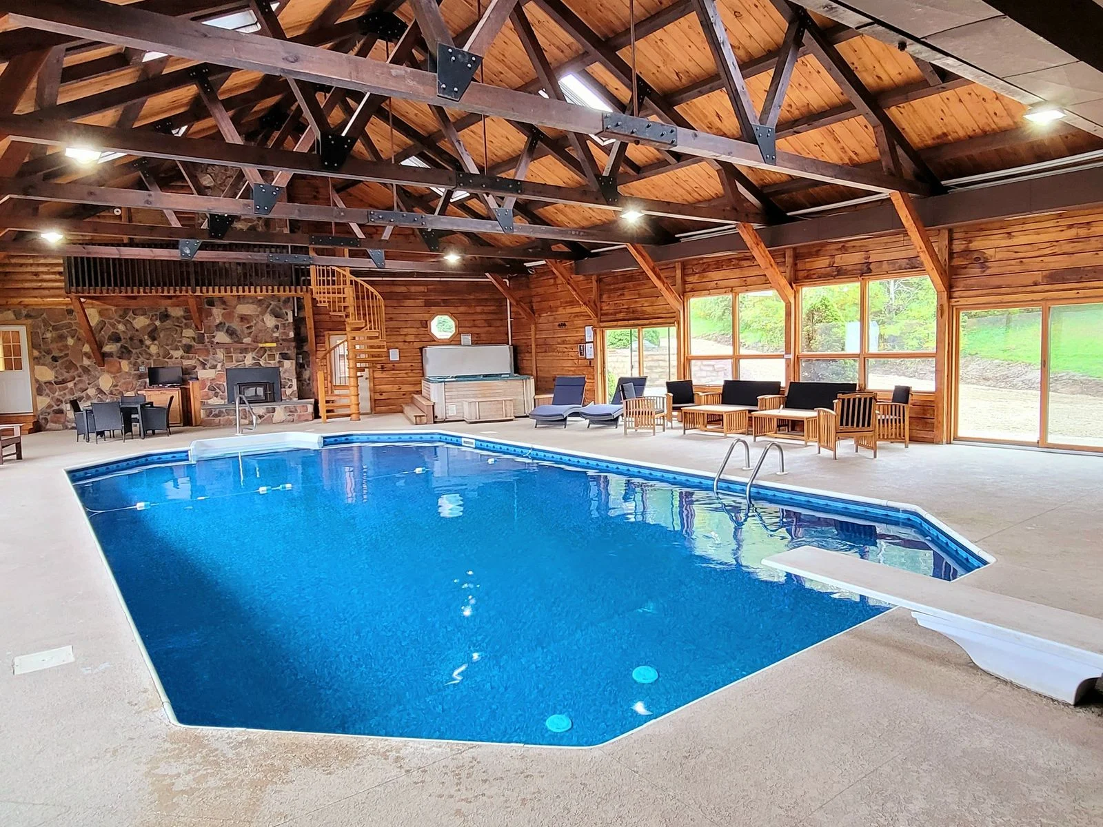 Geometric indoor pool in a woodpaneled room with a vaulted ceiling.