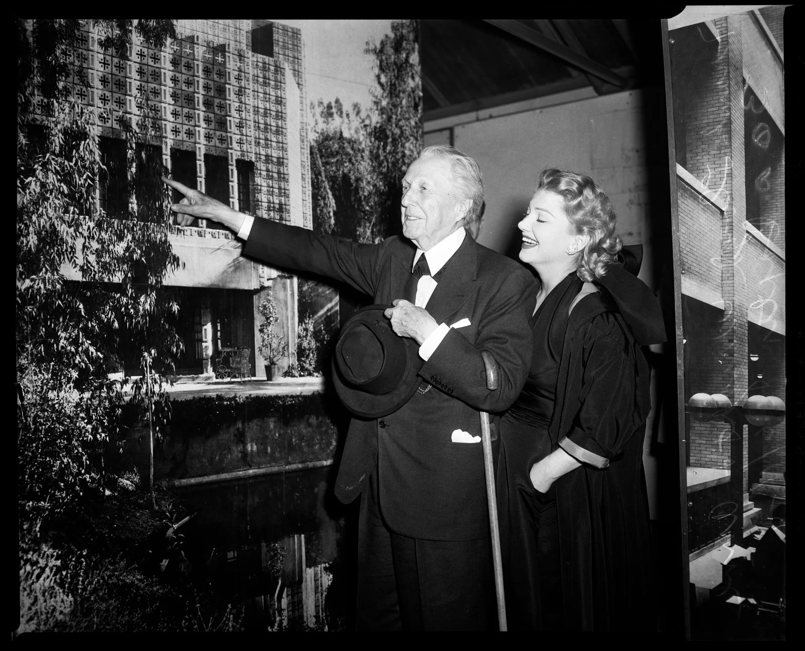 Actress Anne Baxter in front of photo mural of one of his designed buildings