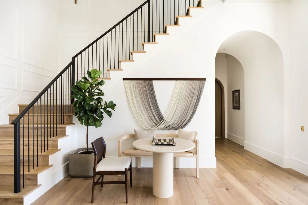 To balance out the arch in the hallway Cooke opted for straight lines when designing the staircase railing. The black...