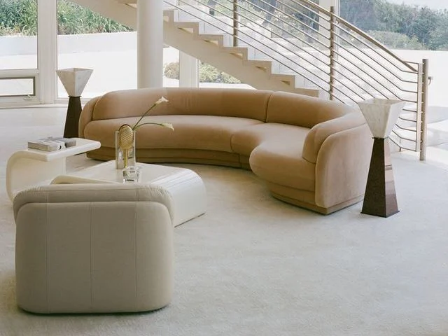 Curvaceous tan couch in a minimalist living room.