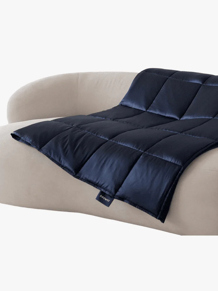 Dark blue weighted blanket over white couch