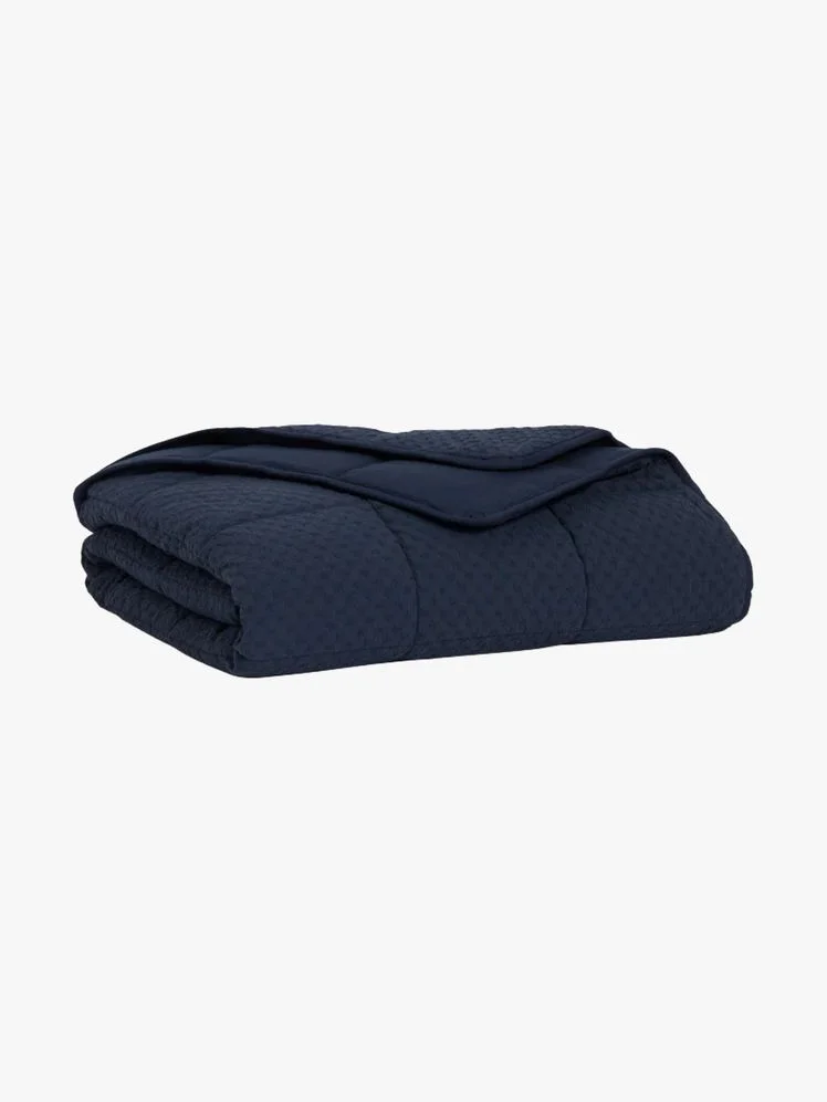 Navy blue weighted blanket folded up.