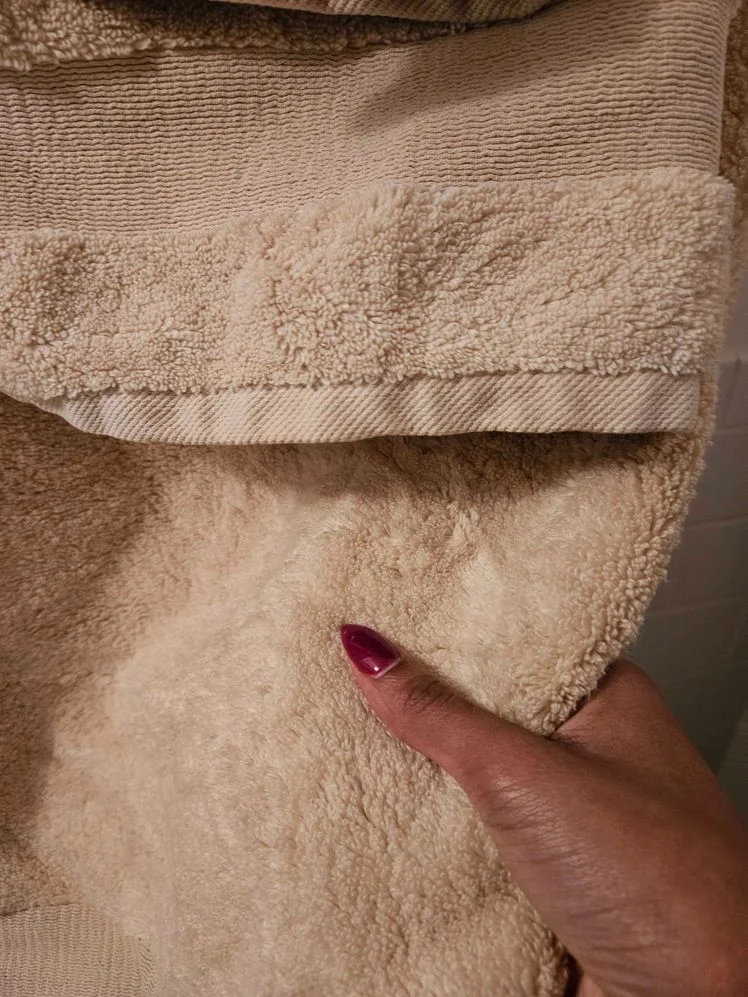 Person's hand holding a towel to show its texture.