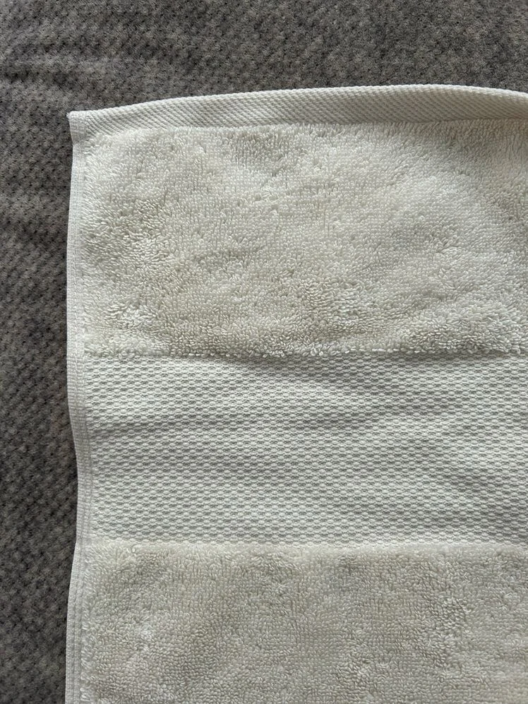 Corner of a yellow bath towel.