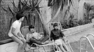 The Beatles  Paul George and Ringo sitting along pooldeck