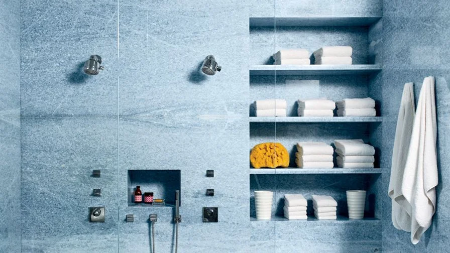 Bathroom with builtin shelf in shower holding assorted towels.