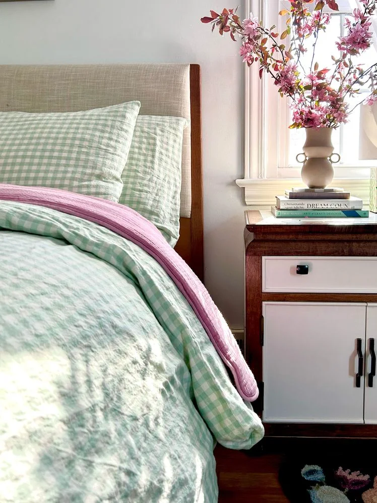 Image may contain: Furniture, Book, Publication, Bed, Cushion, Home Decor, Bed Sheet, Pillow, Flower, and Plant