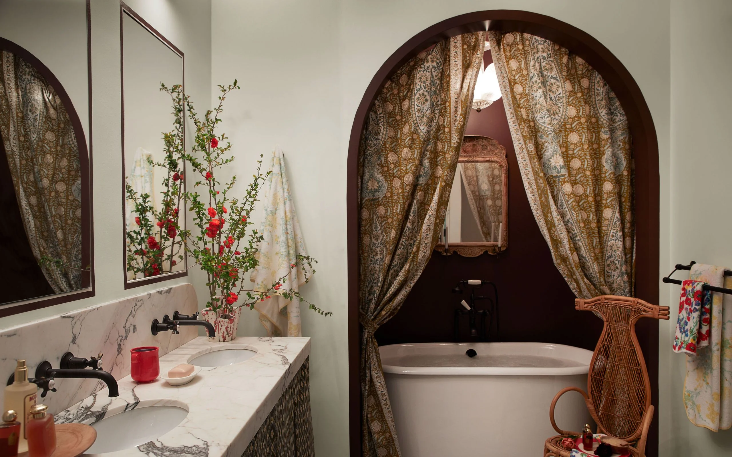 Bathroom with tub in curtained off in a archway cutout in the wall.