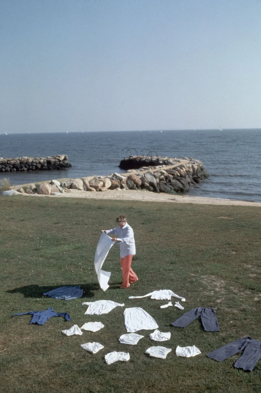 Katharine Hepburn lying laundry out on the lawn of her waterfront home