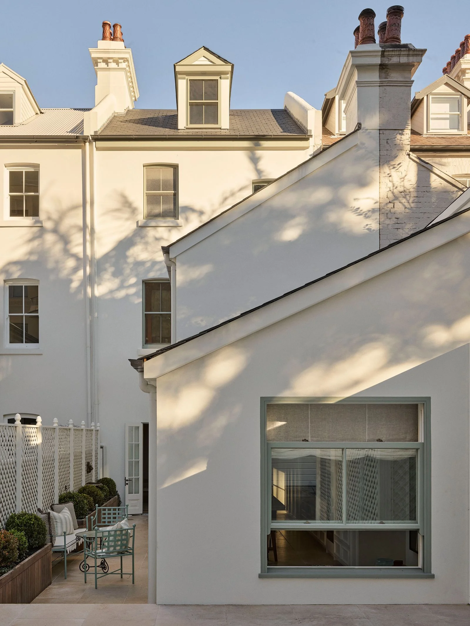 Image may contain City Architecture Building Housing Plant Window Urban House Chair Furniture and Bay Window