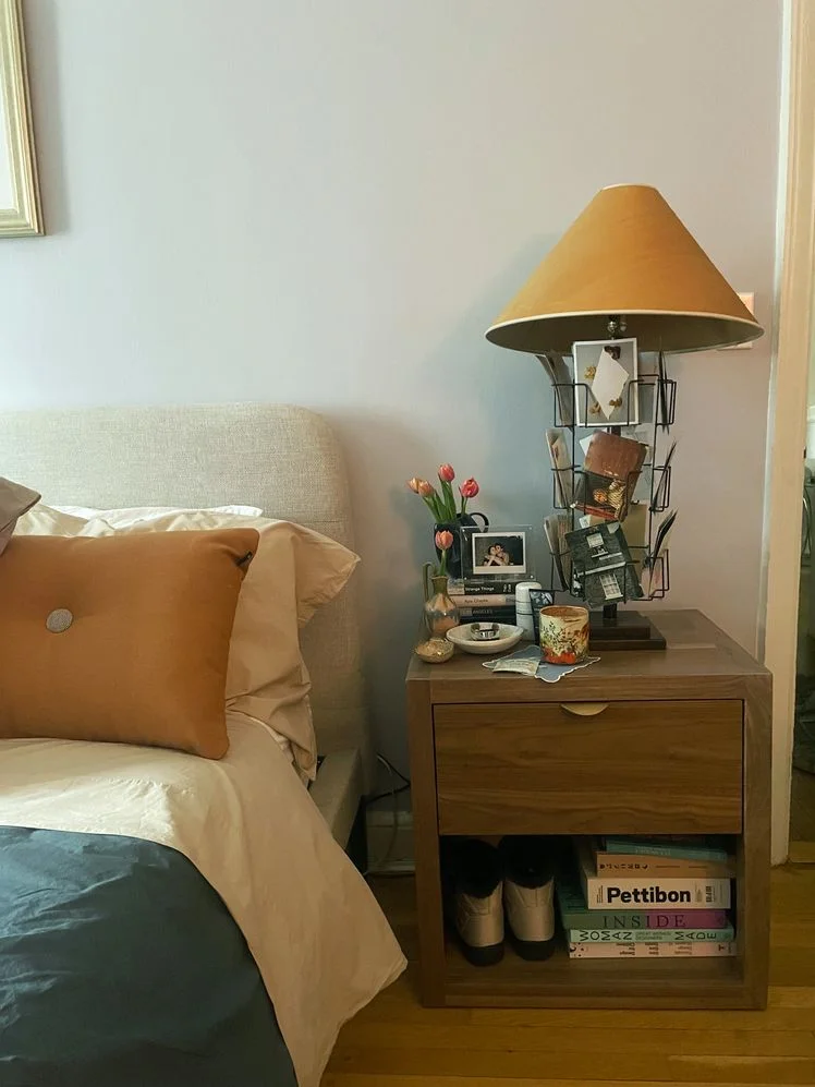 Avocado Malibu Wood Nightstand styled with books and lamp with postcards