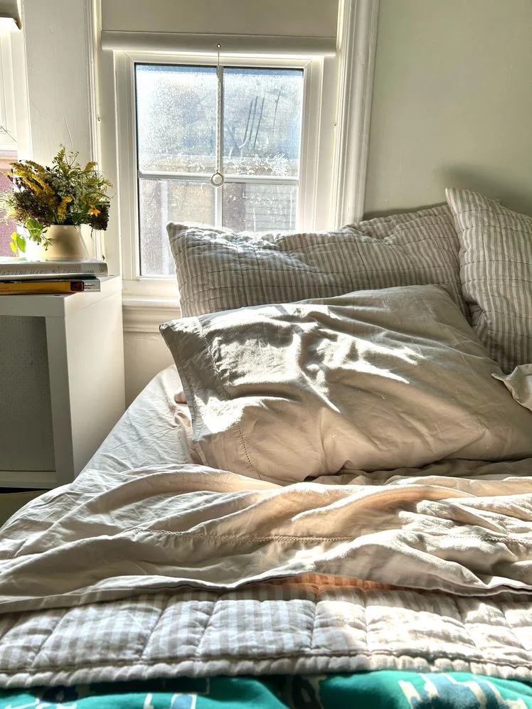Bed made with grey sheets.